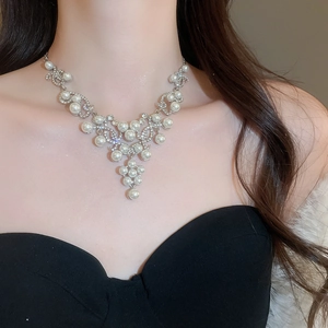 Detailed view of luxury silver teardrop pearl necklace with sparkling rhinestones on model