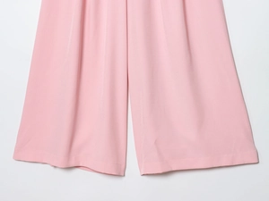 Close-up of pink wide-leg pants showing premium woven fabric texture and hem detail