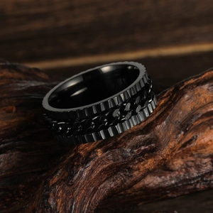 Vintage Herrenring aus schwarzem Edelstahl mit Kette auf rustikalem Holzuntergrund