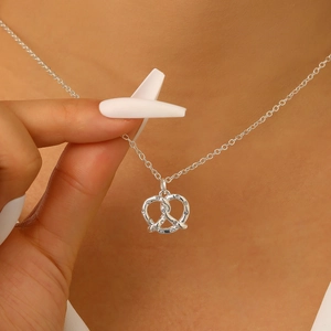 Collana con ciondolo a bretzel argento e micro cristalli indossata per uno stile unico
