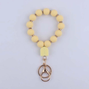 Detail of yellow silicone beaded keychain with U-shaped charm and gold metal ring clasp