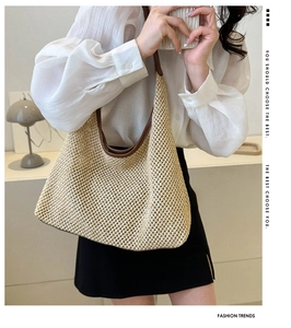 Detail of hollow woven tote bag featuring brown leather trim and shoulder strap on model