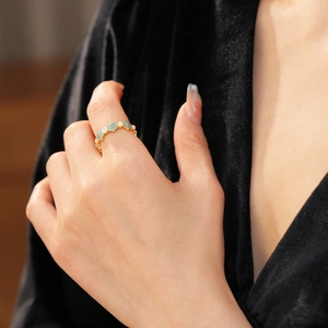 Close-up of vintage 18k gold plated enamel flower ring worn on a finger