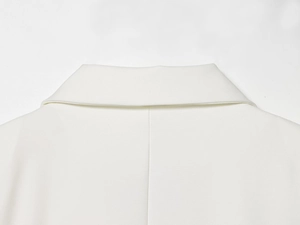 Detail of a white blazer collar showing high-quality stitching and woven fabric texture