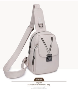 Détail du sac de poitrine en cuir crème avec rivets noirs en V et boucle métallique