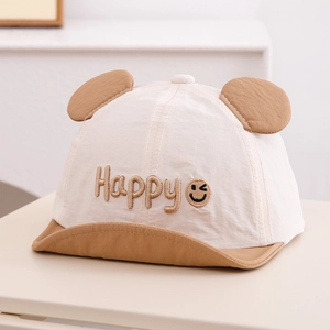 Détail de la casquette bébé avec broderie happy et oreilles décoratives en coton doux