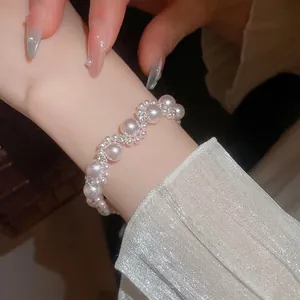 Elegant French-style pearl bracelet with sparkling diamond accents on a model wrist