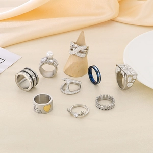 Various creative geometric stainless steel rings with rhinestones on beige fabric background