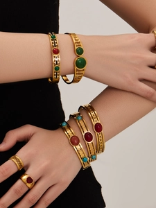 Detail of vintage hollow gold bracelets and rings with turquoise and red agate stones
