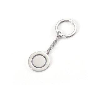 Close-up of polished silver stainless steel rotating disk pendant keychain on white background