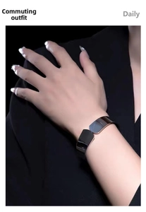 Close-up of polished silver stainless steel wide cuff bracelet on a dark blazer