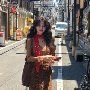 Detail of leopard print camisole dress paired with a red polka dot neck scarf in street style