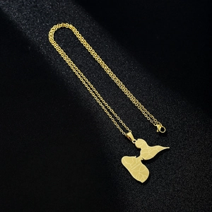 Macro shot of gold Guadeloupe map pendant in stainless steel on black texture