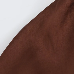 Detail view of dark brown midi dress fabric showing plain weave texture and matte finish