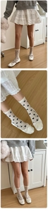 Detail of sheer polka dot socks with ribbons paired with white ballet flats