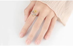 Detailed close-up of a rotating sunflower and bee ring with yellow gemstone accents