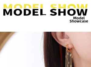 Detailed view of 18k gold plated heart-shaped earrings with fine chain tassels on a model