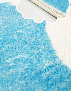 Detailed close-up showing soft cashmere-like texture and blue wavy pattern on a bath mat