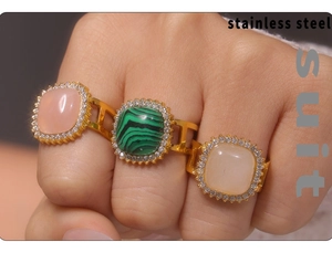 Detailed view of three gold PVD plated stainless steel rings with zircon and natural stones