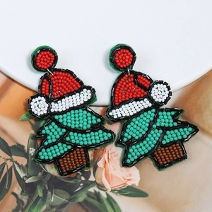 Close-up of handmade beaded Christmas tree and Santa hat earrings with intricate beadwork