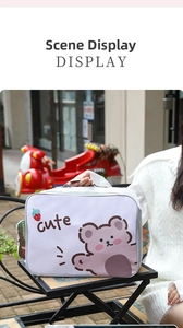 Detail view of a white cartoon travel bag with pink bear print and silver zipper