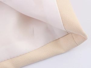 Detailed close-up showing the beige canvas texture and white lining of the suit jacket