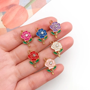 Handheld showcase of colorful alloy rose charms with crystal stones for DIY jewelry