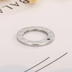 Detail of silver stainless steel hammered round charm pendant with hole for DIY jewelry