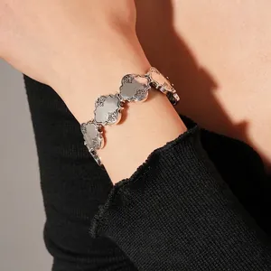 Bracelet vintage argenté à maillons trèfles avec gravure baroque sur fond tricoté noir
