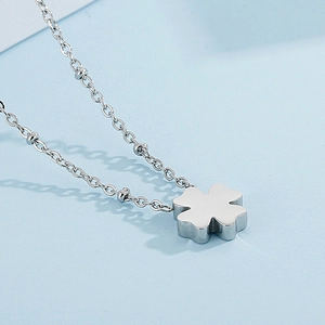 Elegant silver stainless steel four-leaf clover pendant necklace on light blue surface