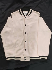 Detail of color-block baseball jacket collar with black and white striped ribbed cuffs