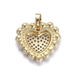 Macro shot of gold heart pendant with pearl border and textured grid back detail