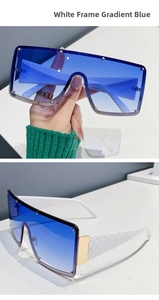 Macro detail of oversized white sunglasses featuring gradient blue lenses and quilted temples