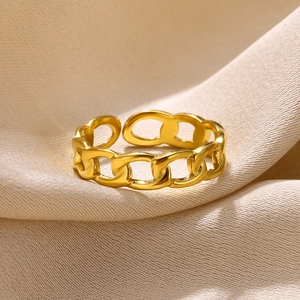 Macro shot of gold-plated curb chain open ring on soft elegant silk background