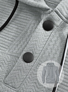 Détail d'un sweat à capuche gris pour homme avec tissu à chevrons et col boutonné