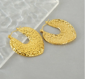 Détail des boucles d'oreilles plaquées or 18 carats avec texture martelée et forme en C