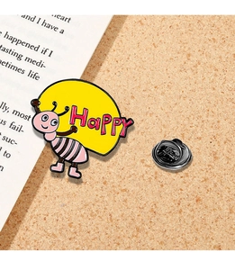Detail of pink striped bee enamel pin with Happy sign and black rubber clutch backing