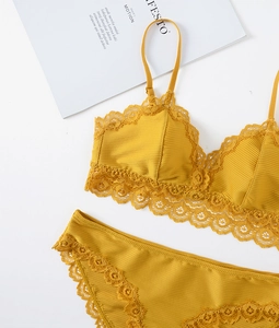 Flat lay of ginger yellow lace lingerie set with ribbed fabric and delicate flower trim