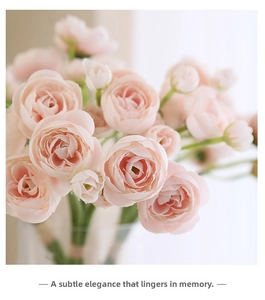 Close-up of pink artificial camellia bouquet with multilayered petals in a glass vase