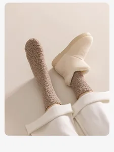 Gros plan de chaussettes en molleton de corail doux et bottines d'intérieur en peluche
