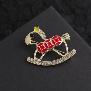 Exquisite rocking horse brooch with red enamel and crystals in a festive gold finish