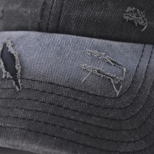 Macro detail of distressed washed baseball cap with vintage frayed edges and reinforced stitching