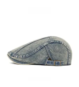 Detail view of washed denim flat cap featuring bronze metal buckle and vintage stitching