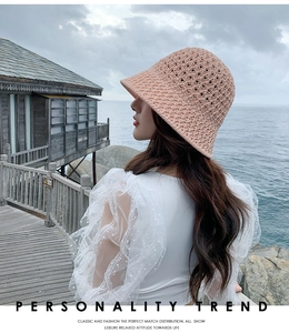 Détail d'un chapeau bob en maille crochet rose ajouré dans un décor extérieur naturel