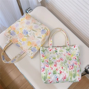 Détail de sacs fourre-tout en toile à fleurs et aquarelle sur une chaise blanche