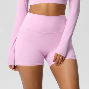 Gros plan sur le short de yoga rose taille haute avec poches latérales et tissu élastique