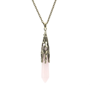Close-up of hexagonal rose quartz crystal pendant with vintage bronze metal cap detailing