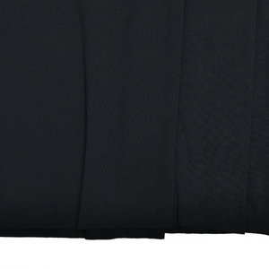 Close-up macro view of the ruched black knitted fabric texture on women long dress