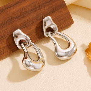 Irregular silver-tone double-loop drop earrings on a neutral textured surface