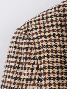Detailaufnahme des hochwertigen Hahnentritt-Wollstoffs und der Schulternaht am braunen Blazer